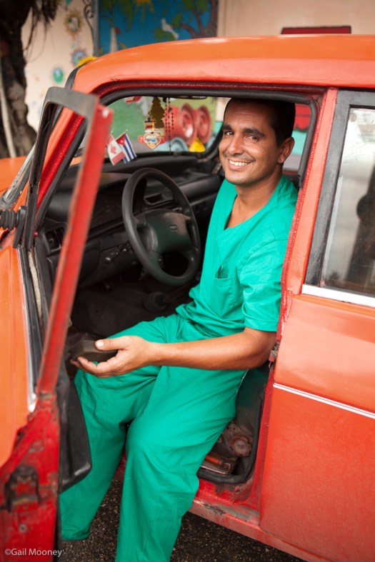 Man with armarall, cleaning car. Havana, Cuba